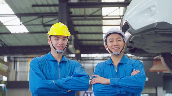 Portrait of Asian two handsome automotive mechanic men stand in garage.