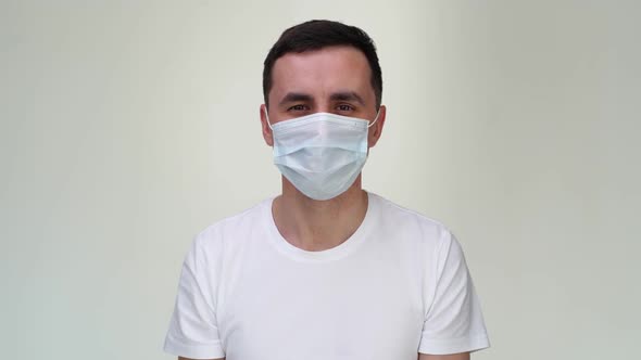 Happy Caucasian Young Man in Medical Mask Is Showing Thumbs Up Gesture.