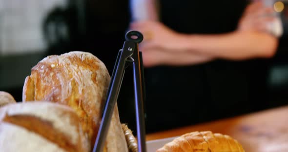 Portrait of waitress standing at counter with bread loaf