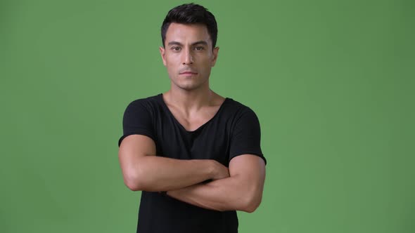 Young Handsome Hispanic Man Against Green Background