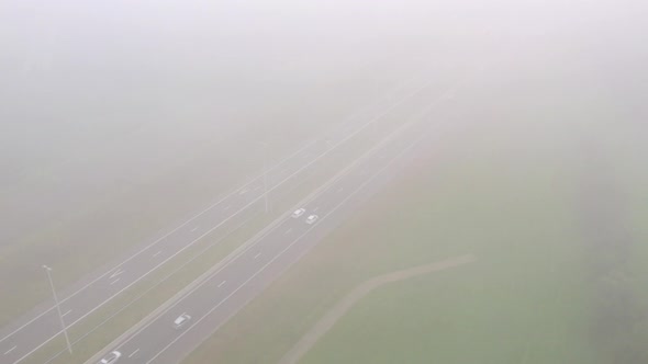 Overhead View of Cars Driving on a Highway Next to a Railroad on a Misty Day During Summer in