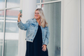 Urban portrait young woman plus size wearing denim texting on mobile phone - PhotoDune Item for Sale