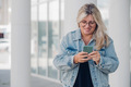 Urban portrait young woman plus size wearing denim texting on mobile phone - PhotoDune Item for Sale