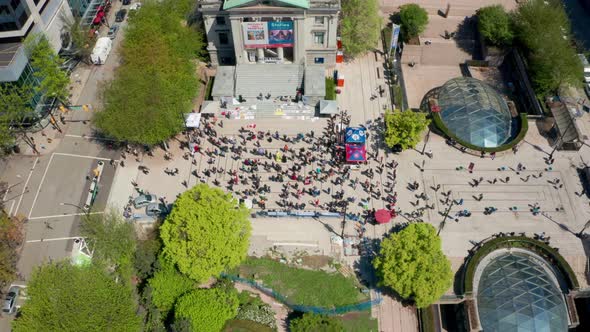 People gather to demonstrate in a public square, aerial drone view. Anti-vax anti-mask conservatives