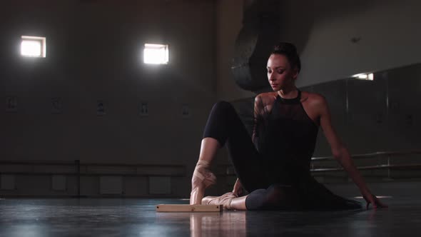 Young Woman Testing the Tip of Her Pointe Shoe