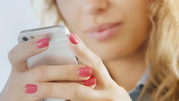 Hands of a Young Woman with a Mobile Phone, Smiling Lips Slightly Blurred