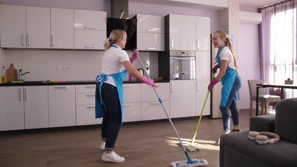Joyful Cleaners Singing and Dancing While Mopping