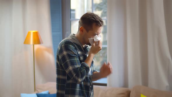 Sick Man Blowing His Runny Nose in Paper Tissue Walking at Home