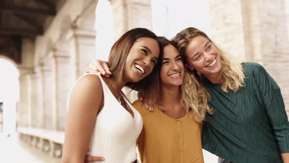 Three Cheerful Multiracial Women Laughing Together and Having Fun in the Street