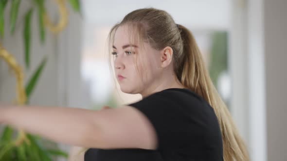 Closeup of Serious Concentrated Plussize Woman Boxing Shadow on Morning Training at Home