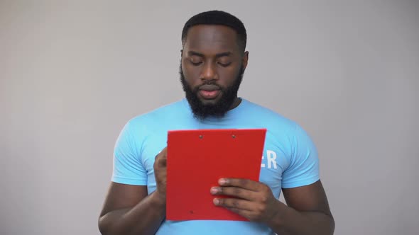 Black Male Volunteer Filling Data in Registration Form, Festival Organization