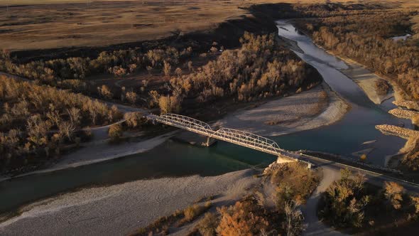 Drone approaching an old truss bridge made of steel near pincher creek in Alberta, Canada during col