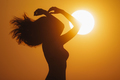 Profile of Young Bikini Beach Woman Silhouetted Against a Big Golden Sun Disk - PhotoDune Item for Sale