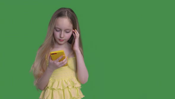 Teen Girl with Long Hairs Is Browsing Her Mobile Phone on Keyed Green Background