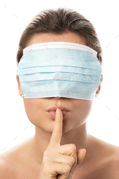  making shush gesture. Concepts of conspiracy theory or misinformation about Covid-19 pandemic.