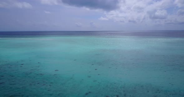 Daytime overhead tourism shot of a sunshine white sandy paradise beach and turquoise sea background 