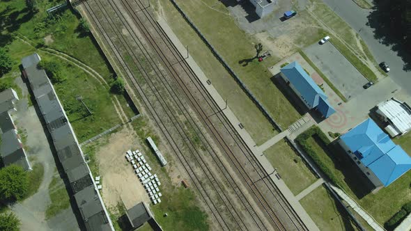 Flight Over Suburban Railway Station. Railway Rails And Sleepers Are Visible. Station Buildings