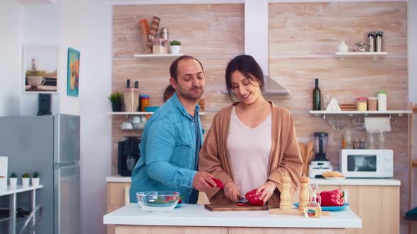 Cheerful Man in Kitchen with Wife