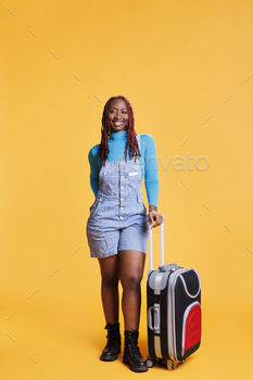  leave on plane with suitcase travel bags. Female model leaving on urban adventure holiday, excited modern traveller in studio.