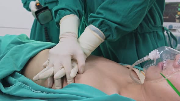 Close up of doctor cpr and use defibrillator electric device to shock heart on intensive patient.