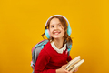 Schoolgirl with backpack, headphone and books in hand back to school - PhotoDune Item for Sale