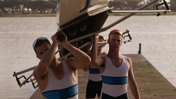 Male rower team putting the boat on their shoulders