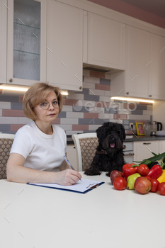  feeding ration for a black curly dog. Kitchen, white table, fruit