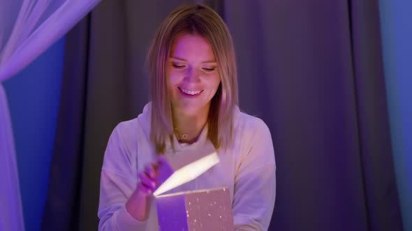 Beautiful Blonde Young Woman Opening Surprise Gift Box with Light Inside RED 8K