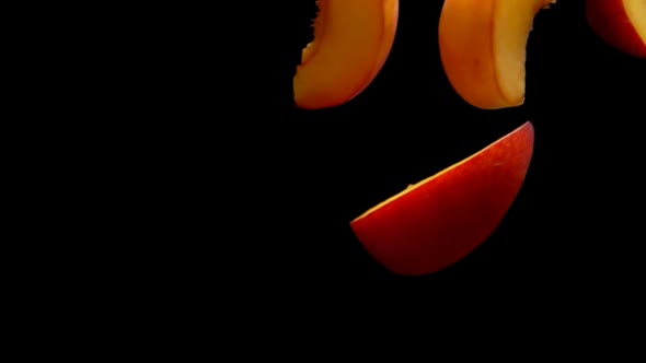 Closeup of the Fresh Peach Slices Flying Diagonally on the Black Background