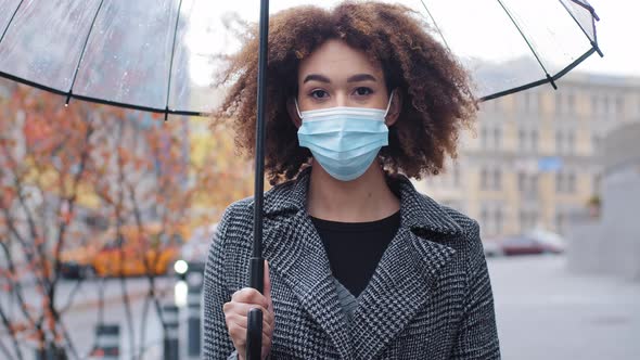 Beautiful Young African American Woman Girl with Curly Hair with Transparent Umbrella Stands in City