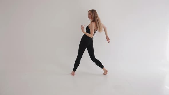 Sensual Young Girl is Engaged in Stretching with Dance Elements in the Studio and Makes Smooth