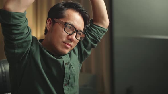 Close Up Asian Man Stretching While Works On Personal Computer And 3D Printer In Home Office