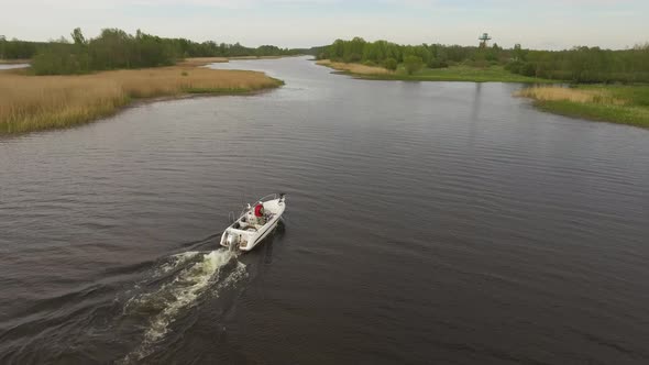 Camera Follows the Boat Sailing on the River Aerial Image