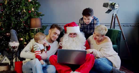 Happy Family Together Santa Claus Sitting Sofa Floors Looking Laptop