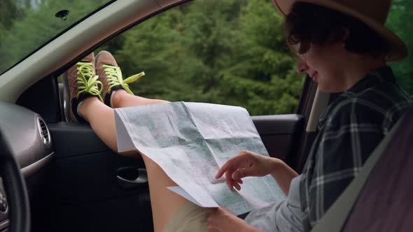 Traveling By Car, Tourist Girl Sitting In The Car Holding A Map Looking Out Looking For A Short Trip