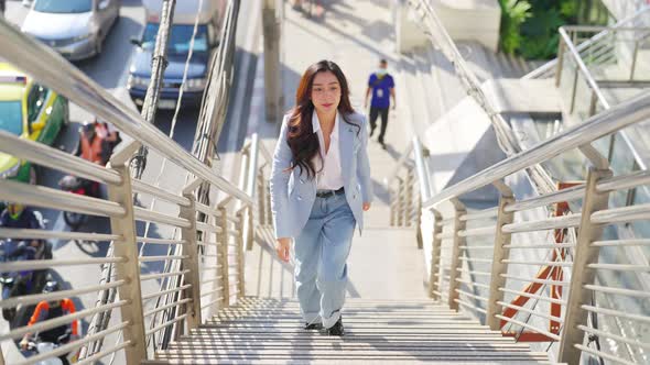 4K Asian business woman walking up staircase at railway station