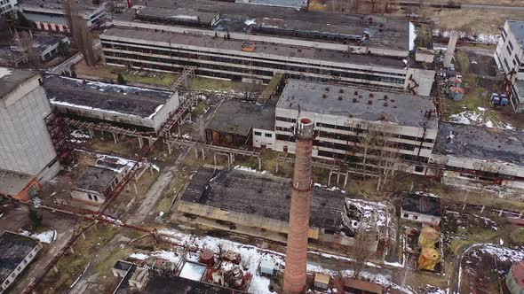 Old industrial zone with ruined buildings. Empty abandoned factory with brick edifices in place. 