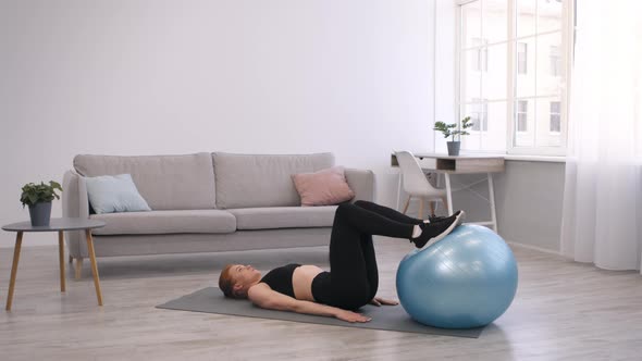 Fitness Woman Exercising With Fitball Lying On Floor At Home