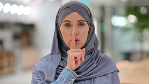 Assertive Arab Woman with Finger on Lips Quiet Sign