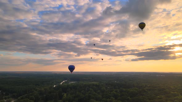 Aerial Drone View of Colorful Hot Air Balloons Flying Over Green Park and River in Small European