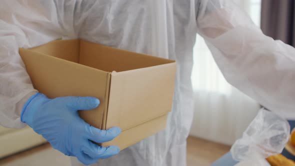 Close Up of Volunteer Packing Food in Box