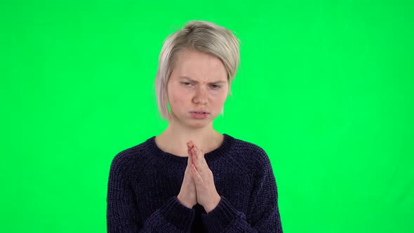 Portrait of Blonde Girl with Creative Haircut Is Clapping Her Hands Indifferent on a Green Screen
