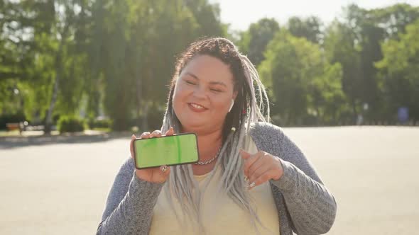 Beautiful Stout Girl with Chromakey on Her Smartphone Advertising Mobile App. Commercial, Copy Space