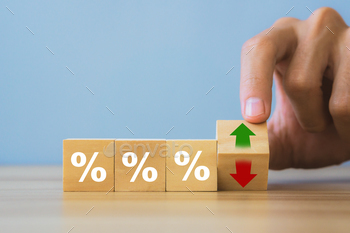 holding wooden block with up-down arrow and percentage symbol.Inflation and tax concept.