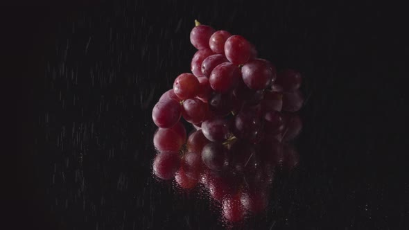 A Bunch Of Grapes Placed On A Mirror With Water Droplets