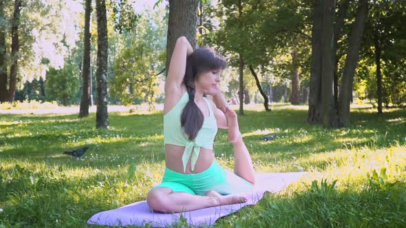 Beautiful Brunette Woman Sportswear Trains Yoga Asana Green Juicy Grass Purple Mat Barefoot Doing