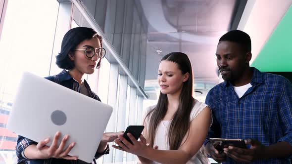 Male and female executives discussing over electronic devices 4k