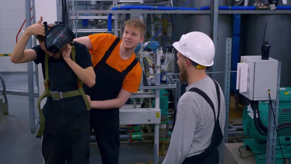 Three Workers at a Chemical Plant are Doing Their Job