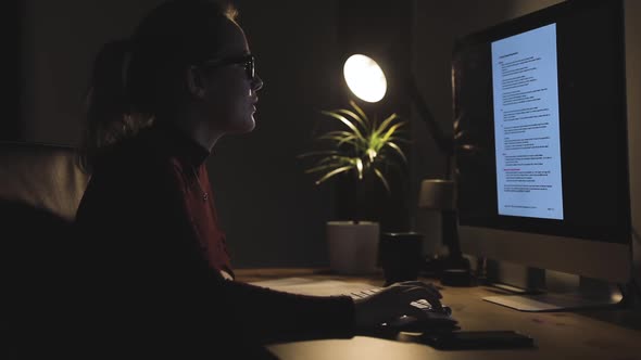 Young woman working at computer station at home