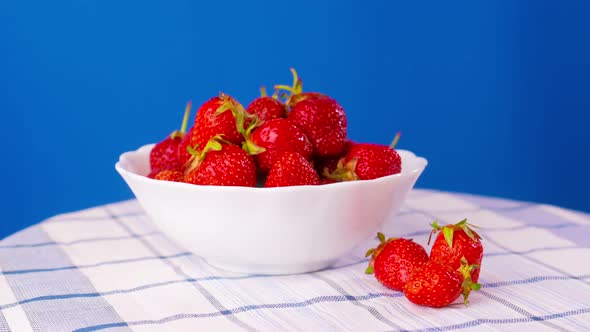Rotation of Juicy Strawberries on Blue Background